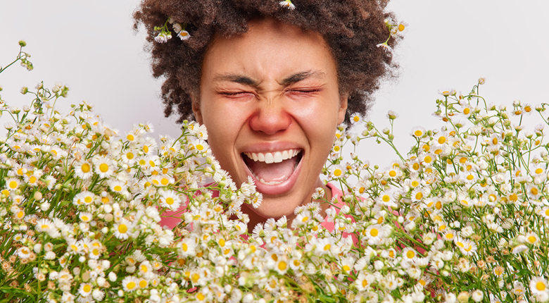 A girl experiencing an allergic reaction to pollen in a pack of flowers.