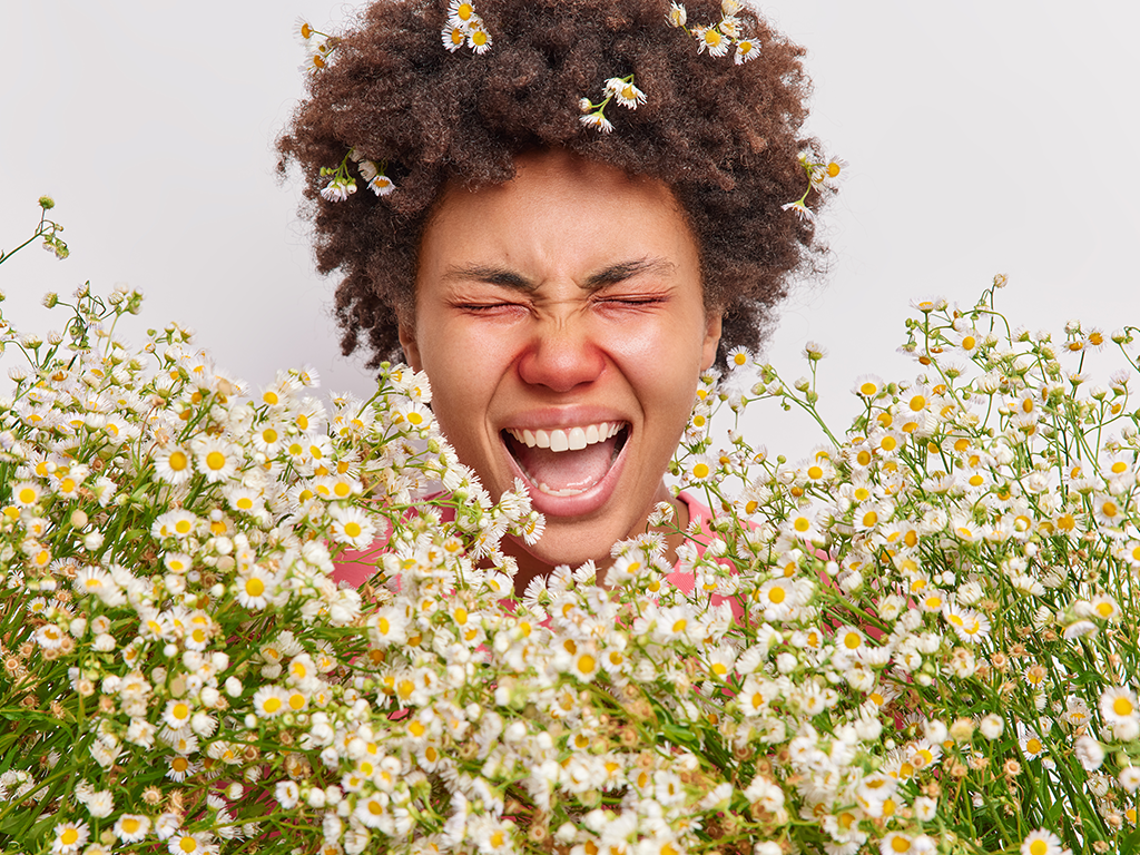 Girl with allergies, red nose, and watery eyes caused by flowers, representing minor ailments.